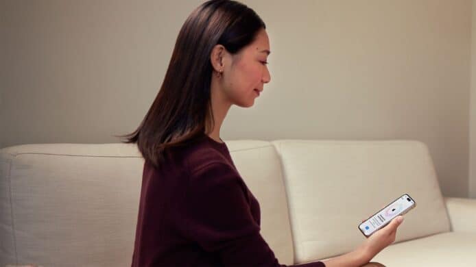 女子正在使用 iPhone，畫面顯示 Apple ID 登入版面